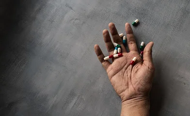 مردی با کپسولهای دارویی در دست